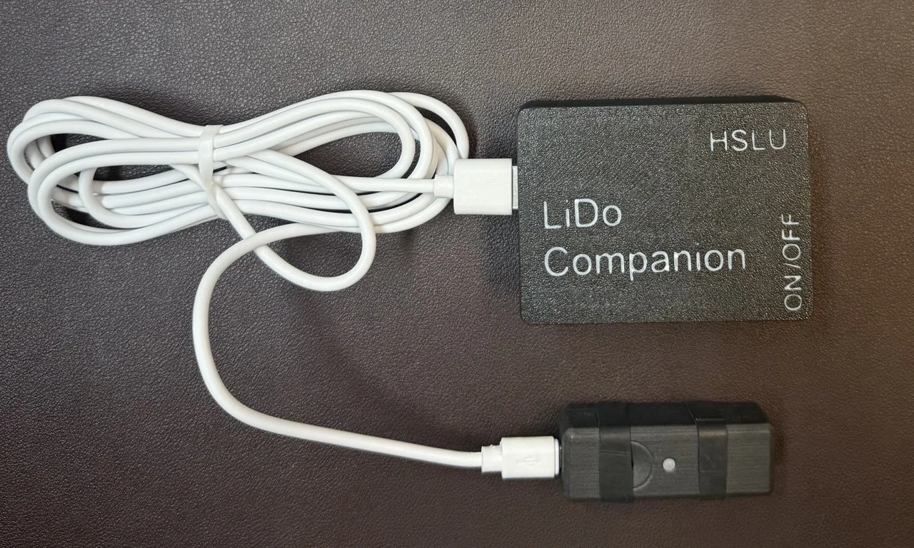 A compact wearable light dosimeter and its companion electronics arranged on a neutral surface.